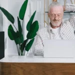 Ιδιοκτήτης ξενώνα αναλύει στατιστικά στοιχεία κρατήσεων σε φορητό υπολογιστή.