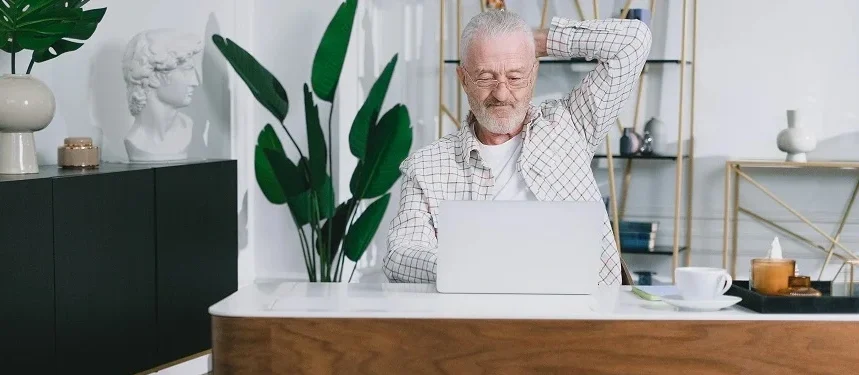 Proprietário de uma pensão a analisar estatísticas de reservas num computador portátil.