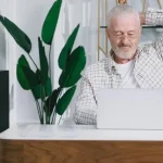 Владелец гостевого дома анализирует статистику бронирования на ноутбуке.