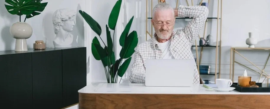 Владелец гостевого дома анализирует статистику бронирования на ноутбуке.