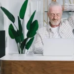 Guesthouse owner analysing booking statistics on a laptop.