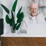 Propriétaire d'une maison d'hôtes analysant les statistiques de réservation sur un ordinateur portable.