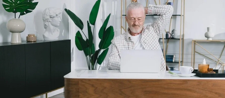 Propriétaire d'une maison d'hôtes analysant les statistiques de réservation sur un ordinateur portable.