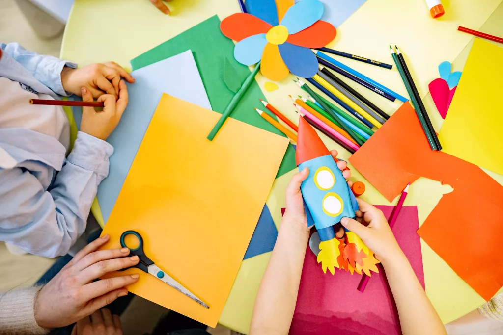 Table with crayons and coloring books - a play area in the apartment for rent for children.
